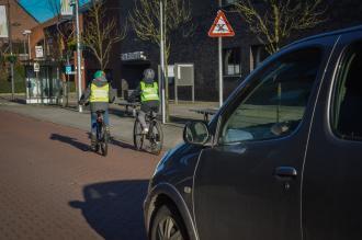 Fotovraag 101457 Vraag: Je komt aangereden met je fiets en ziet een vrachtwagen staan voor het rode licht. Vóór de vrachtwagen is er een opstelvak voor fietsers.