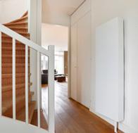 De woonkamer is voorzien van een houten vloer met 10 cm hoge houten plinten, strak gestucte wanden,