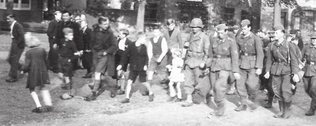 Omgeven door de Eijsdense jeugd worden Duitse krijgsgevangenen op het Vroenhof afgevoerd door de Amerikanen.