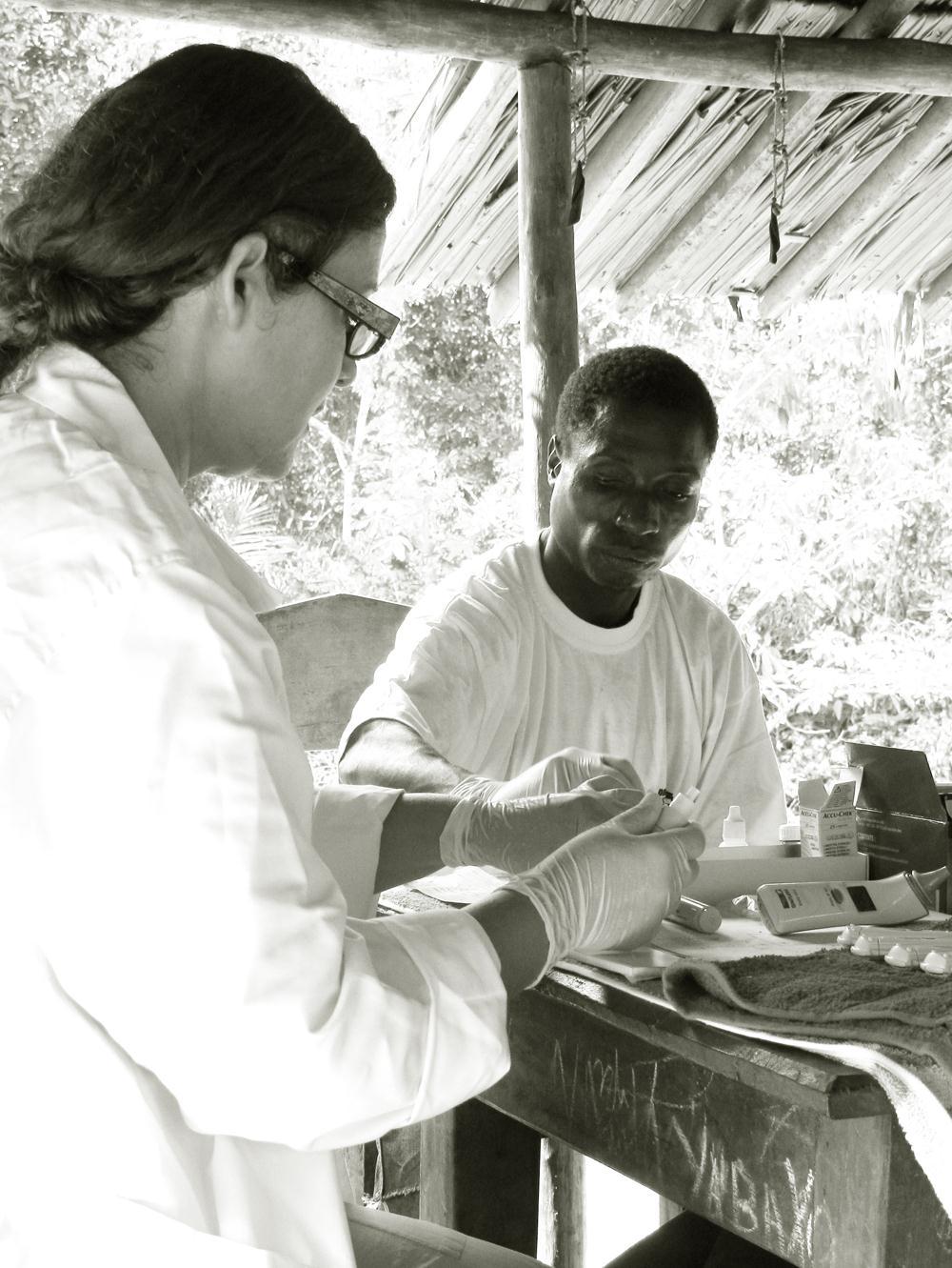 MALARIA OPSPOREN EN BEHANDELEN DAM zorgt ervoor dat de Bayaka gemeenschap in Yandoumbe nauw betrokken is bij de test campagne en weet dat buitenstaanders hen met vrees vervullen.