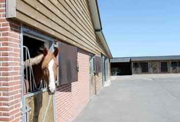 De paardenstal/schuur is opgetrokken uit steensmuren, een betonnen vloer, houten spanten, houten