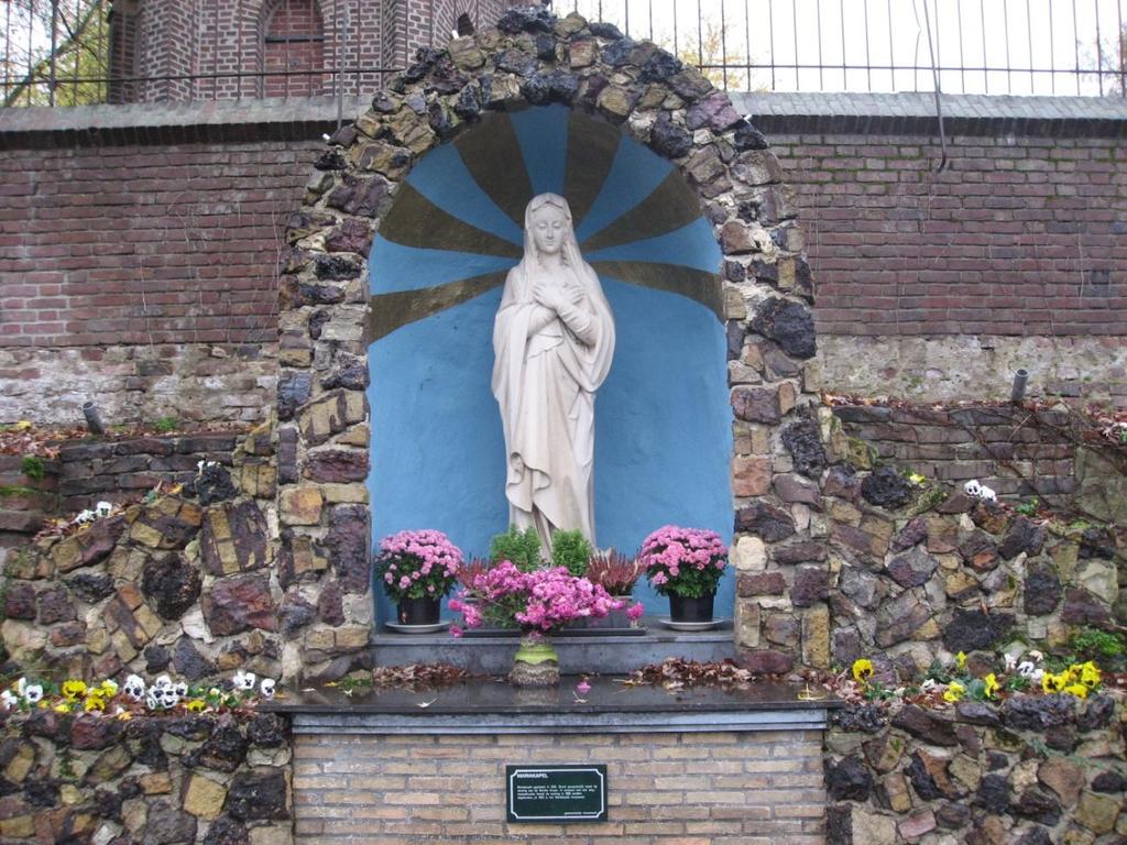 Maria-beeld aan de Heinsbergerweg/Kerkberg te Melick, Het Mariabeeld van zandsteen werd in 1936 geplaatst. Aanvankelijk stond het voor de woning van de familie Knops- Dien (Knops Minkenberg).