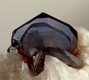 Titaniet met biotietpakket; beeldbreedte 1,3 mm. 6. Lichtoranje, doorschijnend kristal op biotietpakket; beeldbreedte 1,2 mm. 7.