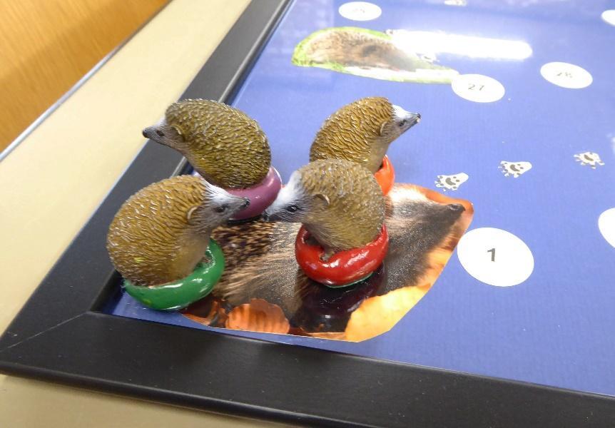 Begin Leg het spelbord op tafel en laat elk kind een egel kiezen (de voetjes hebben verschillende kleuren).