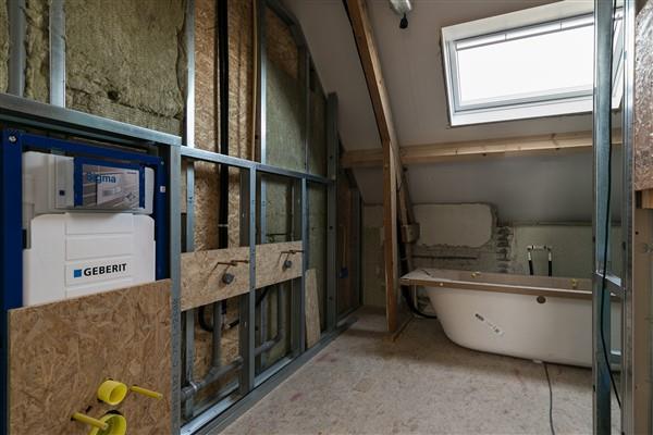 De badkamer is eveneens afgewerkt met een houten (onder)vloer en een geïsoleerd plafond.