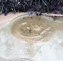 Als rond de wel zand ligt, wordt er materiaal uit de waterkering met het water meegenomen.