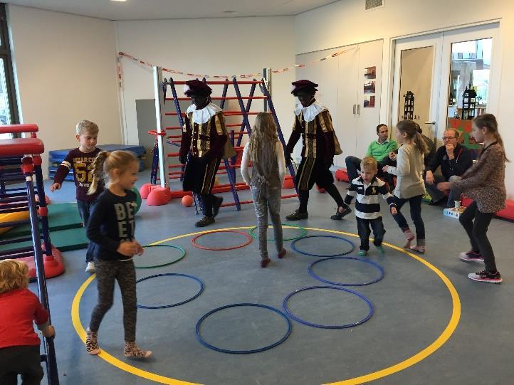 Alle kinderen speelden samen met ballen, hoepels, banken en klimtoestellen. Wat een pret. Na ongeveer een half uurtje spelen, kwamen er twee pieten op bezoek!