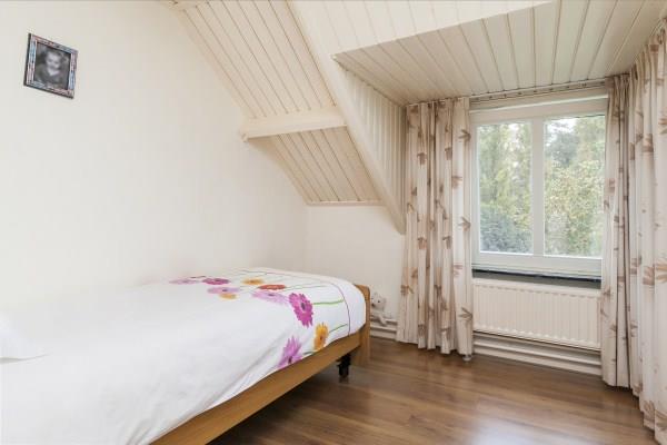 Slaapkamer III is voorzien van een laminaat vloer, schuurwerk wanden, een schroten plafond en een dakkapel.