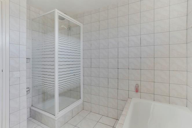 De badkamer is voorzien van een ligbad met thermostaatkraan, een