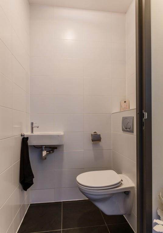 U komt het appartement binnen in de ontvangsthal met de moderne toiletruimte en de toegang tot de woonkeuken.