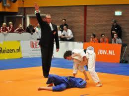 De judoka met de blauwe judogi scoort een ippon