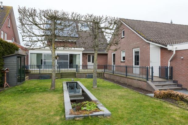 gelegen gazon met een moderne vijver met natuurstenen ombouw, leilinden en een fraai