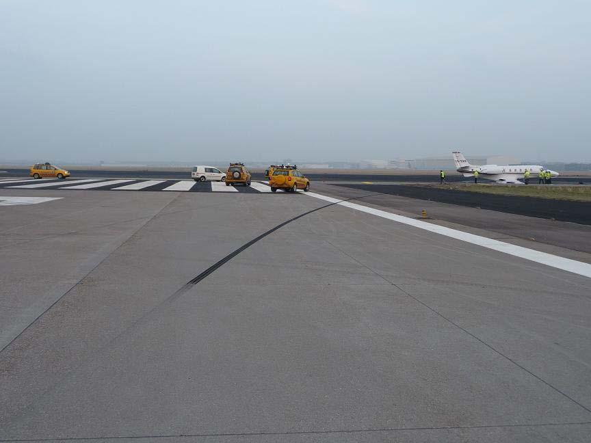 Figuur 4: CS-DXR na voorval met op de voorgrond het remspoor van het rechterhoofdlandingsgestel Volgens de gegevens van de QAR heeft het vliegtuig de landingsbaan van de luchthaven Schiphol