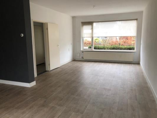 Ruime L-vormige woonkamer van 40 m² met prettig lichtinval en tuincontact.